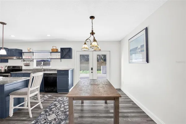 a dining room with furniture a chandelier and wooden floor