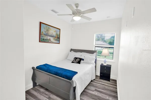 a bedroom with a bed and a painting on the wall