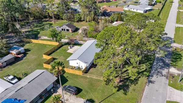 an aerial view of residential houses with outdoor space and trees