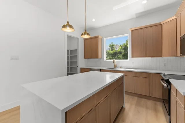 a kitchen with a sink a counter top space and cabinets