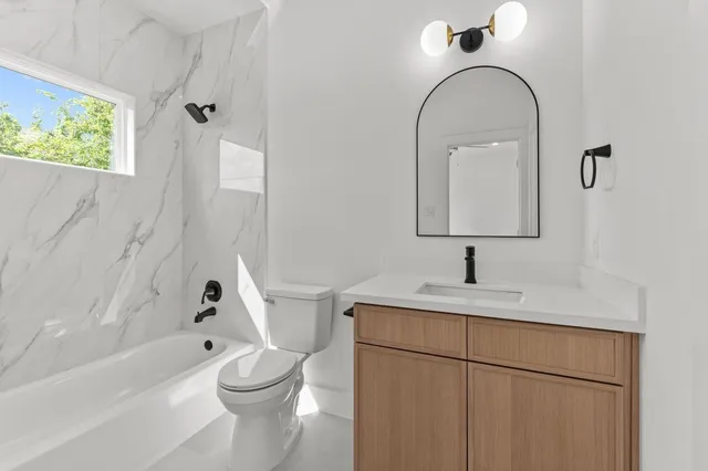 a large white kitchen with a sink a refrigerator and a window