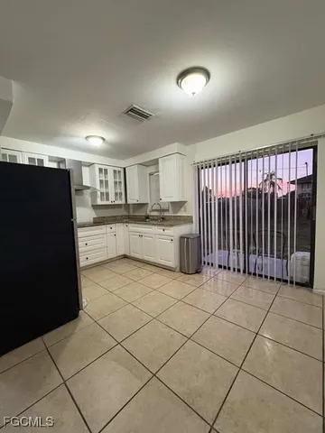 a kitchen with granite countertop a refrigerator and a stove top oven