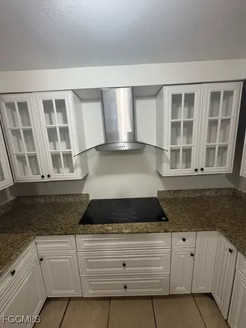 a large white kitchen with granite countertop white cabinets and a granite counter tops