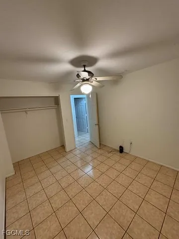 a view of a livingroom with a chandelier fan and kitchen view