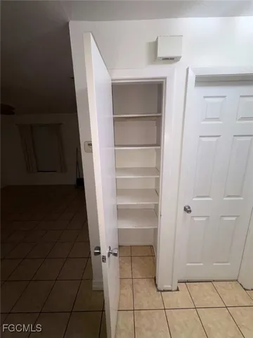 a view of a refrigerator in kitchen and white cabinets
