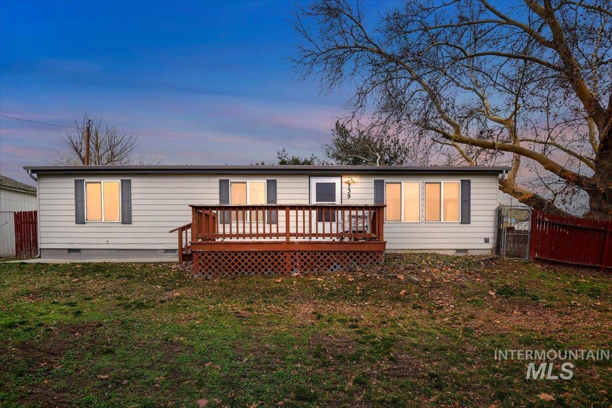 Back of property with crawl space and a wooden deck