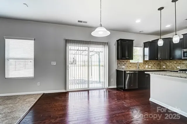 a large kitchen with a large counter top a sink appliances and cabinets