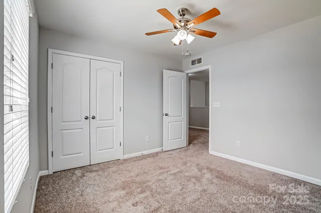 an empty room with fan and windows
