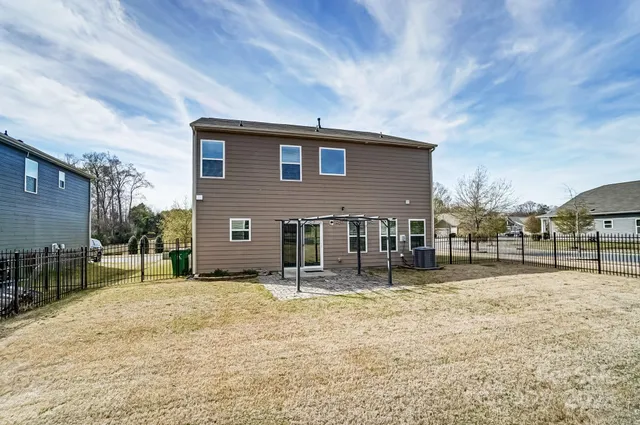 a backyard of a house with swing and table
