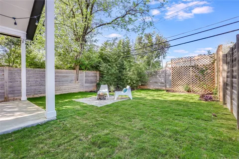 a view of a chair and table in backyard of the house