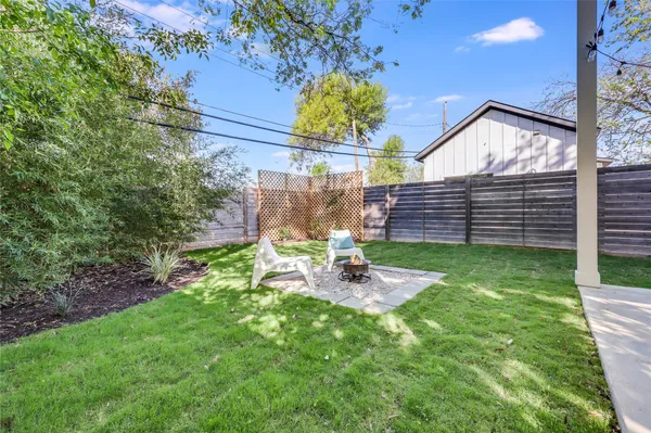 a view of a chair and table in backyard of the house