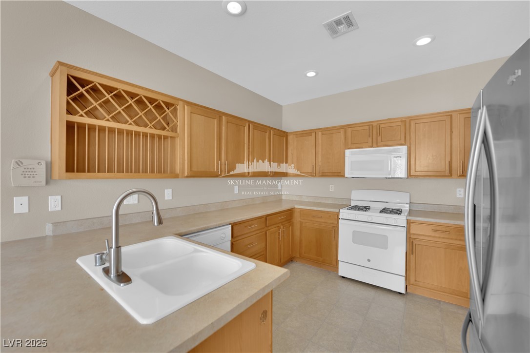 8661 Rowland Bluff Avenue Las Vegas, NV 89178 - Photo 10 of 37 Kitchen featuring white appliances, light countertops, recessed lighting, and light flooring