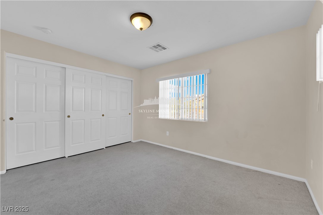 8661 Rowland Bluff Avenue Las Vegas, NV 89178 - Photo 19 of 37 Unfurnished bedroom featuring light colored carpet and a closet