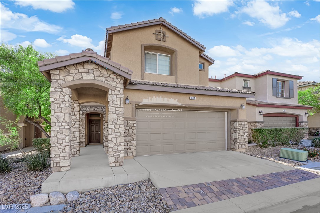8661 Rowland Bluff Avenue Las Vegas, NV 89178 - Photo 2 of 37 Mediterranean / spanish-style home with stone siding, driveway, stucco siding, and a tile roof