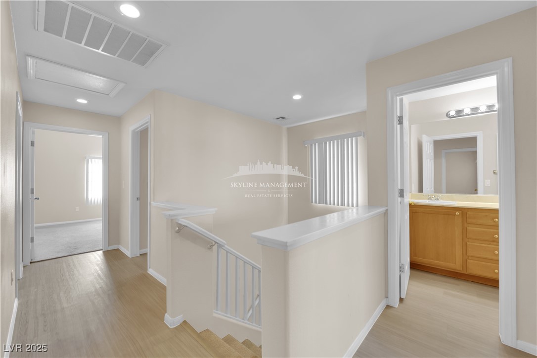 8661 Rowland Bluff Avenue Las Vegas, NV 89178 - Photo 23 of 37 Corridor with an upstairs landing, light wood-style flooring, and recessed lighting
