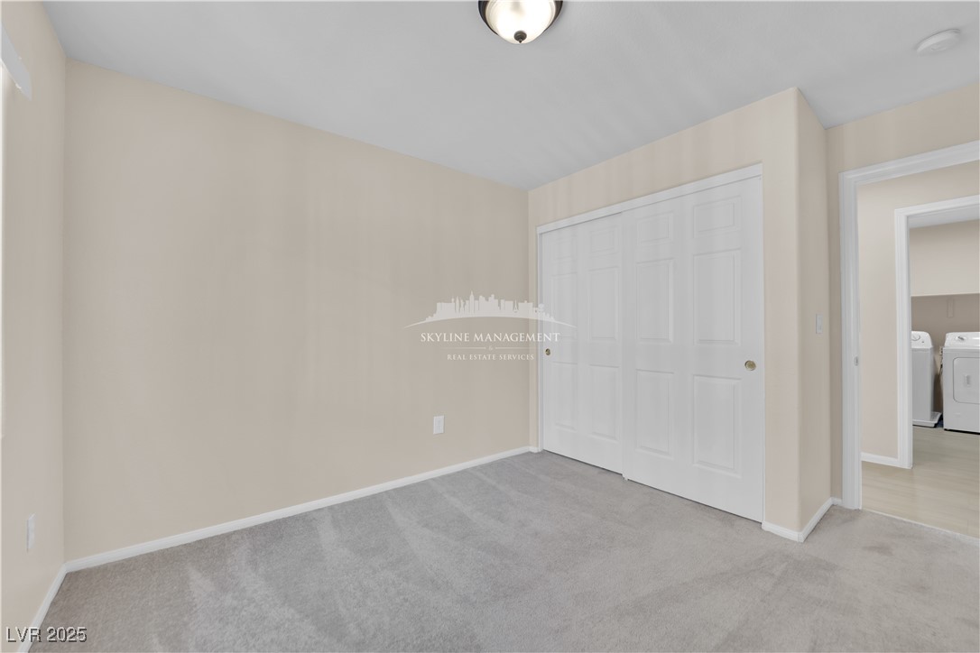 8661 Rowland Bluff Avenue Las Vegas, NV 89178 - Photo 25 of 37 Unfurnished bedroom featuring carpet, a closet, and washing machine and dryer