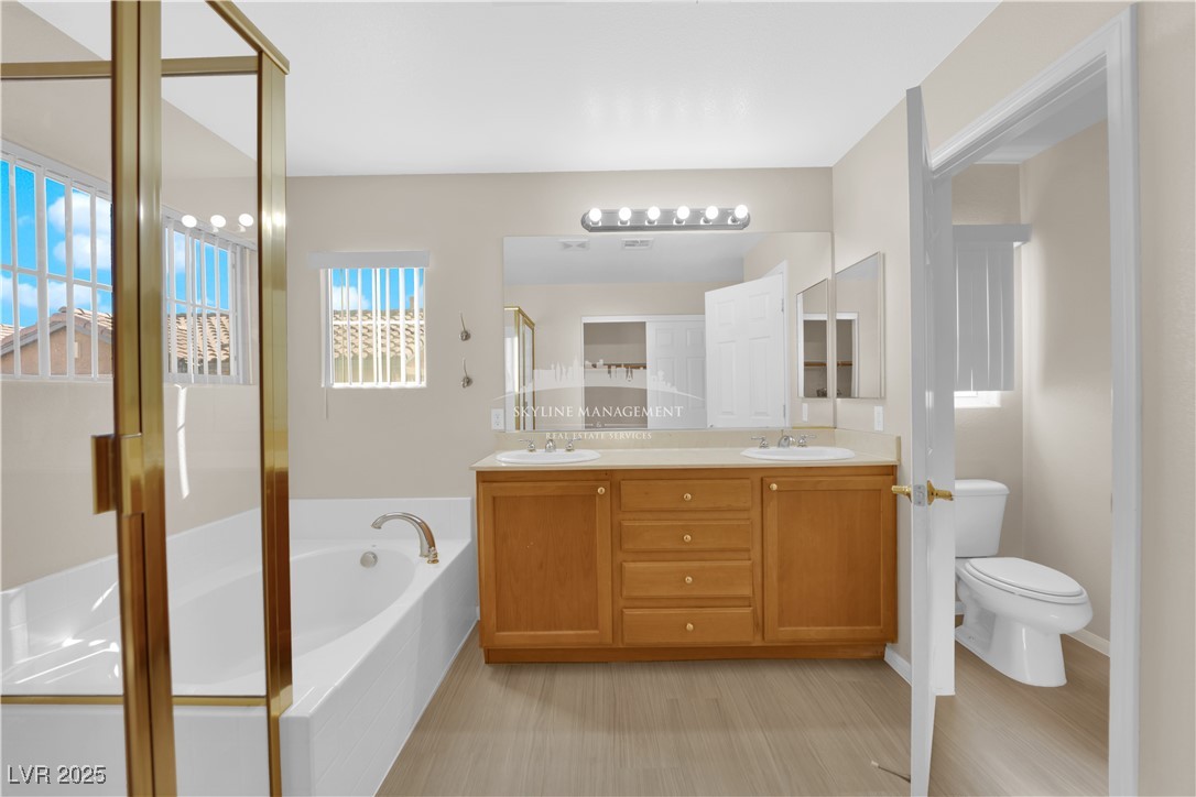 8661 Rowland Bluff Avenue Las Vegas, NV 89178 - Photo 29 of 37 Bathroom with a bath, a stall shower, and double vanity