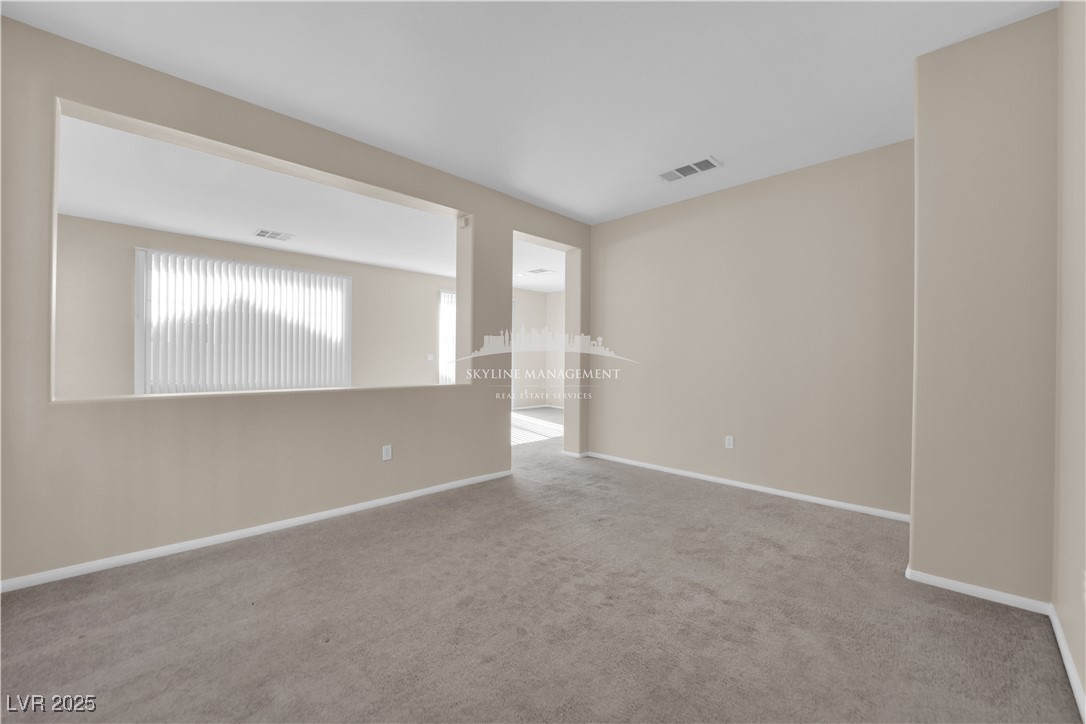 8661 Rowland Bluff Avenue Las Vegas, NV 89178 - Photo 3 of 37 Carpeted empty room featuring baseboards