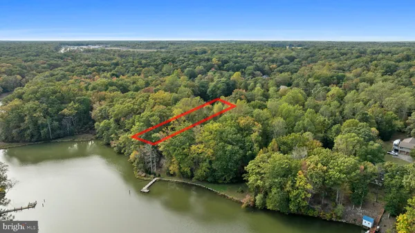 an aerial view of a houses with a yard and lake view