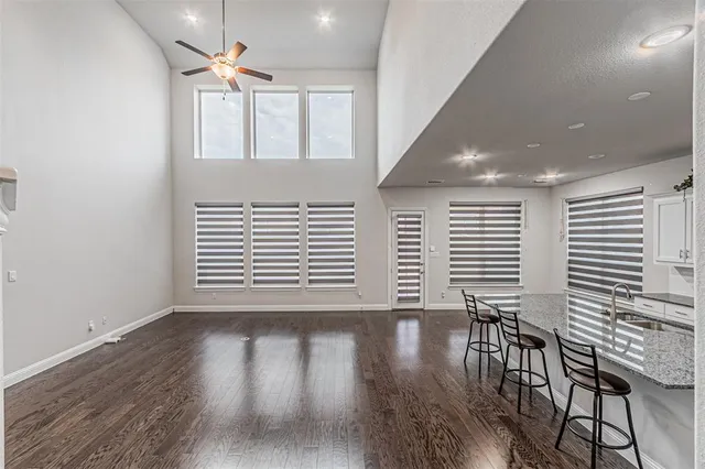 a kitchen with stainless steel appliances granite countertop a stove top oven a dining table and chairs with wooden floor