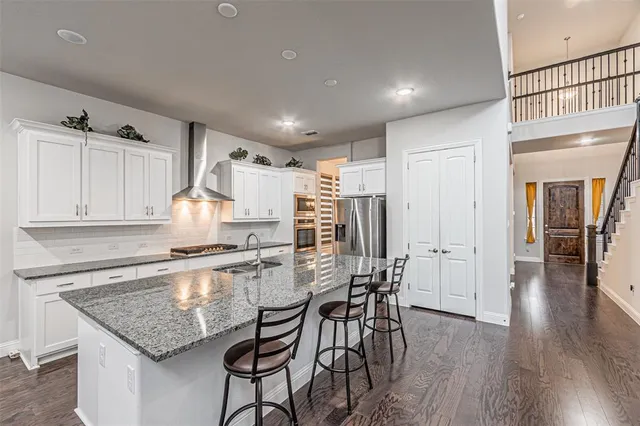 a kitchen with granite countertop a sink cabinets and stainless steel appliances