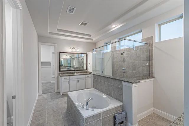 a bathroom with a tub sink shower and mirror