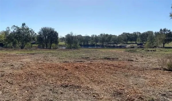 a view of a field with trees in background