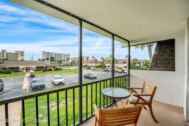 a view of a chair and tables in the balcony
