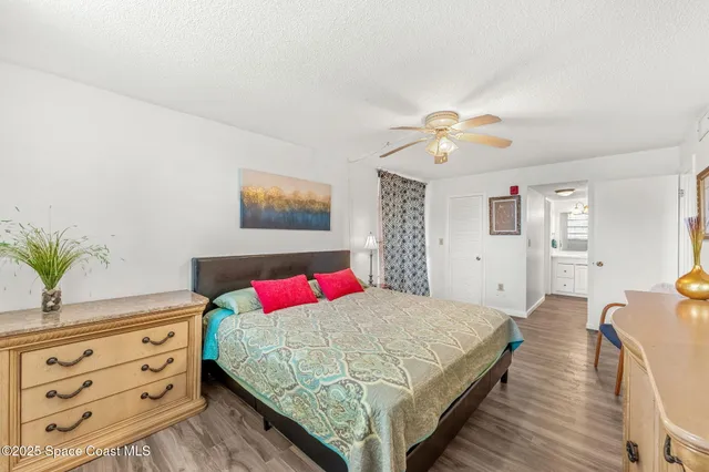 a bedroom with a bed and a potted plant on the dresser