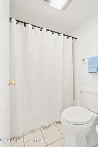 a white toilet sitting next to a shower