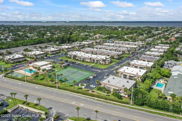 an aerial view of residential houses with outdoor space and ocean view