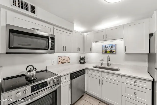 a kitchen with stainless steel appliances a sink stove and microwave