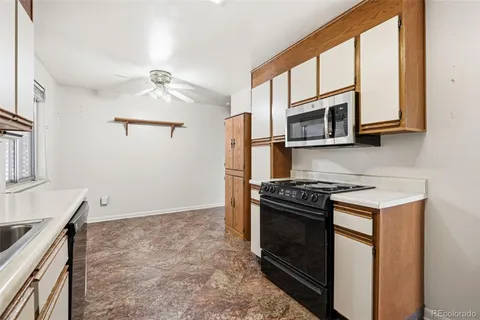 a kitchen with granite countertop a stove and a microwave