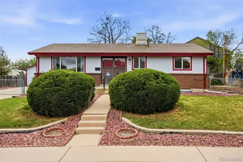 a view of a house with a yard and potted plants