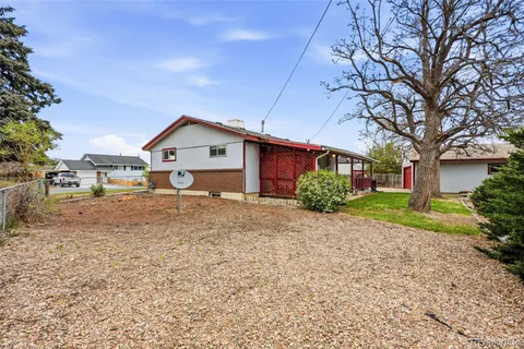 a view of front of house with a big yard and large trees