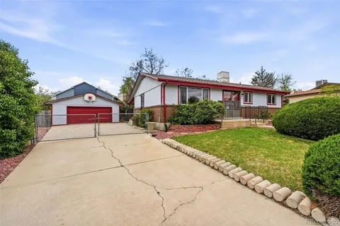 a view of a house with a yard and large tree