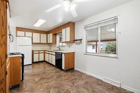 a kitchen with stainless steel appliances granite countertop a refrigerator a sink dishwasher a stove with wooden cabinets and floor