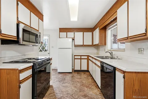 a kitchen with stainless steel appliances granite countertop a sink stove microwave and refrigerator