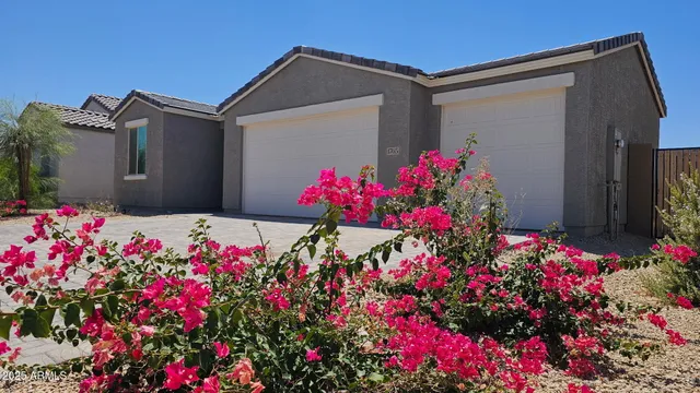 a pink flowers in front of yellow house