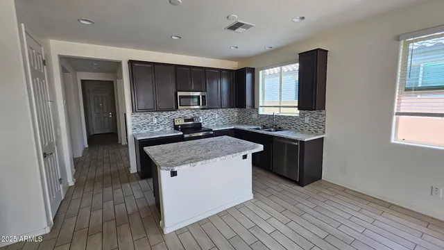 a view of an empty room with wooden floor and a bathroom