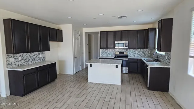 a kitchen with a sink a microwave cabinets and a window