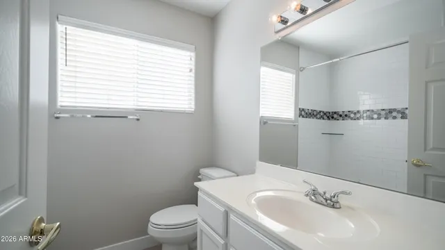 a bathroom with a sink a toilet and a window