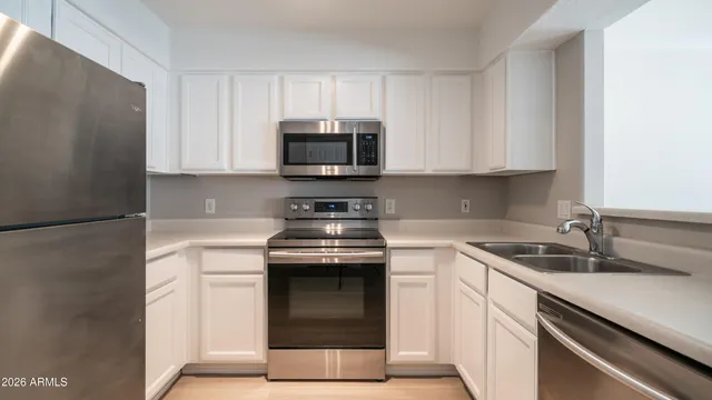 a kitchen with appliances a sink and cabinets