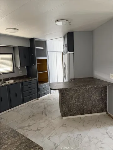 a living room with stainless steel appliances kitchen island granite countertop furniture and a kitchen view