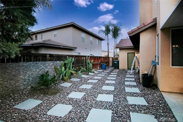 a kitchen with stainless steel appliances granite countertop a stove a refrigerator a kitchen island a dining table and chairs