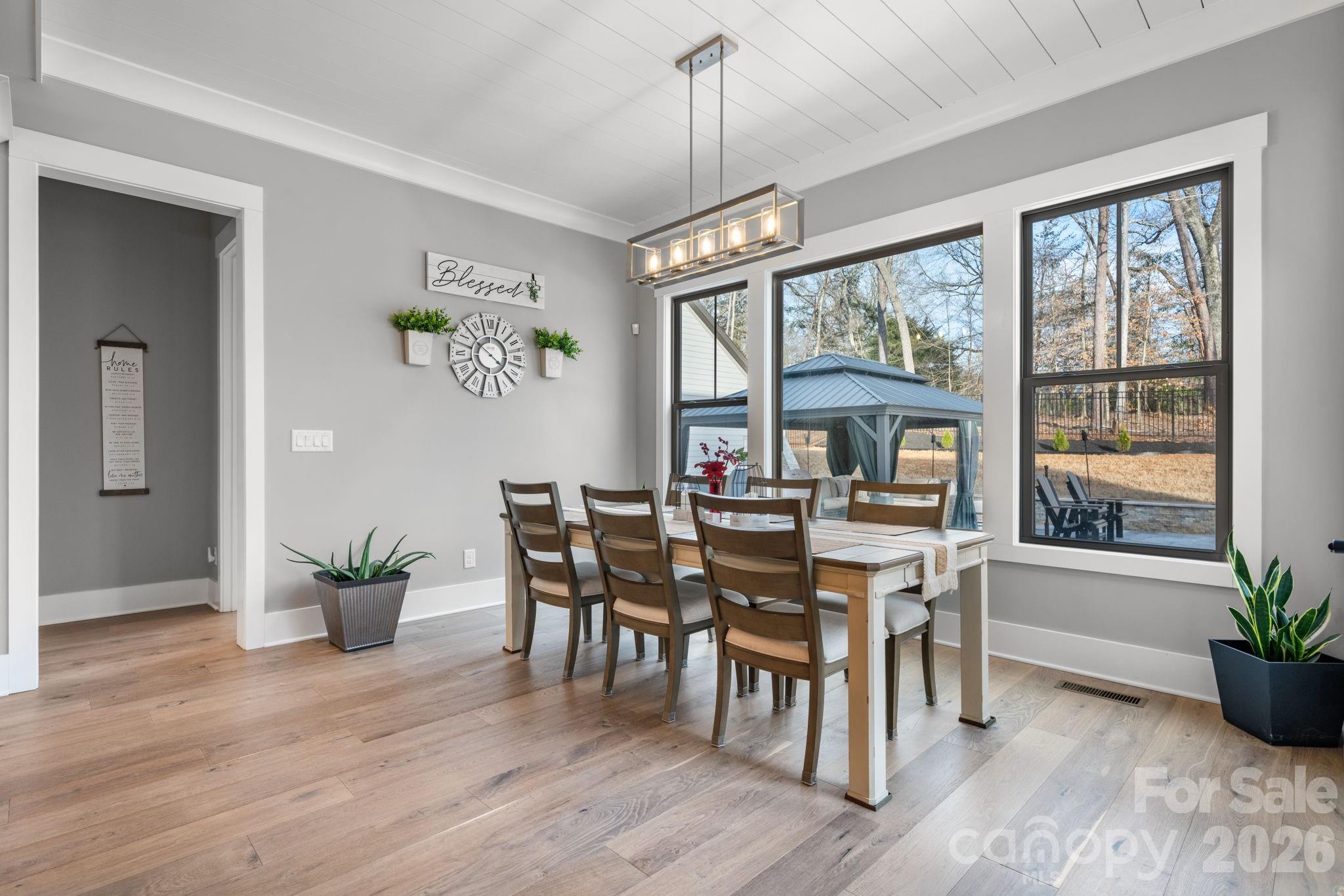 7269 Savannah Denver, NC 28037 - Photo 11 of 48 a dining room with wooden floor a chandelier a wooden table and chairs