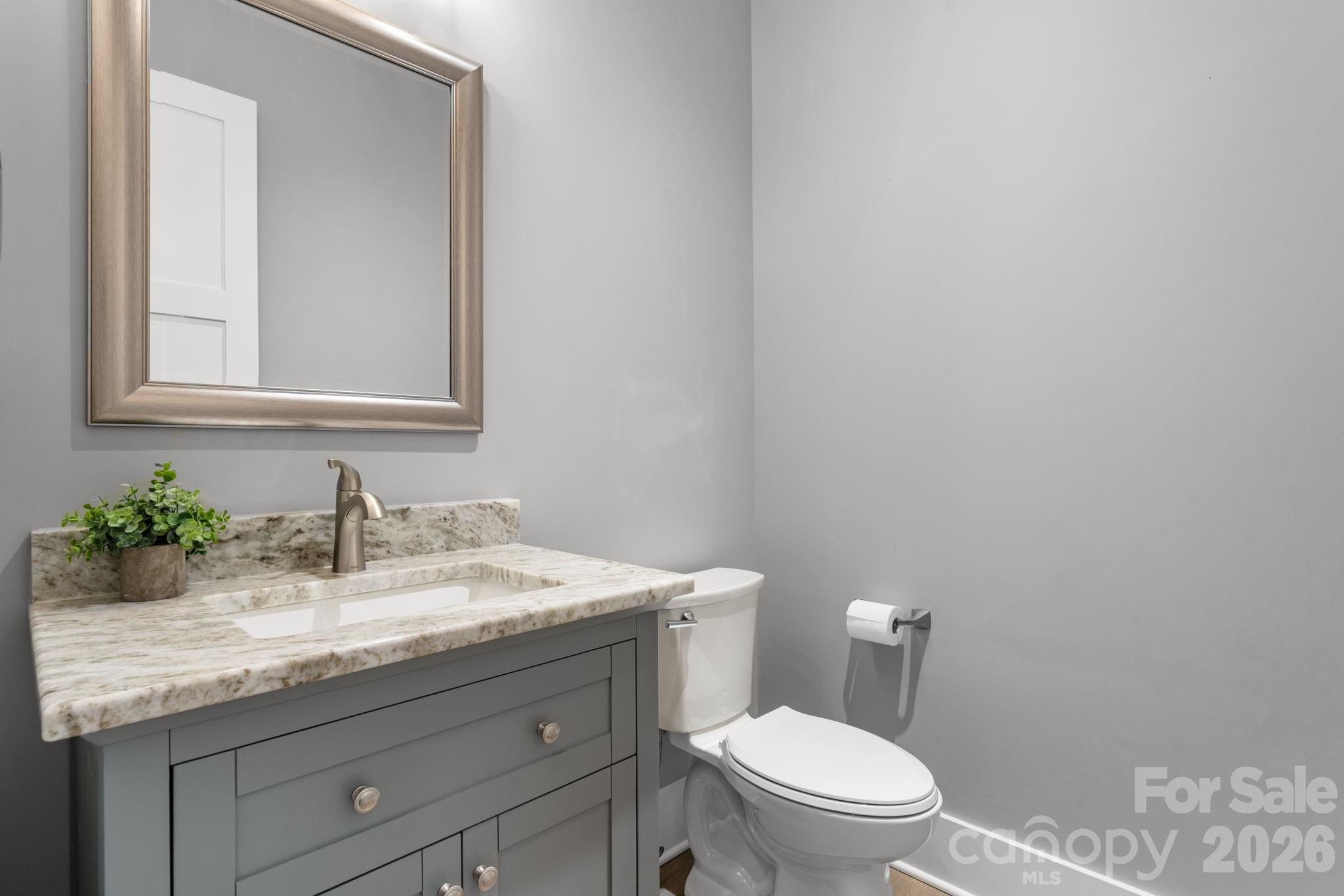 7269 Savannah Denver, NC 28037 - Photo 29 of 48 a bathroom with a granite countertop toilet sink and mirror