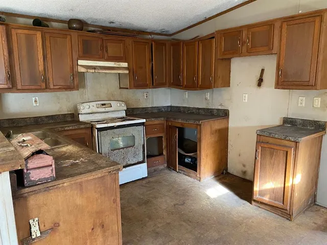 a kitchen with stainless steel appliances granite countertop a stove top oven a sink and dishwasher