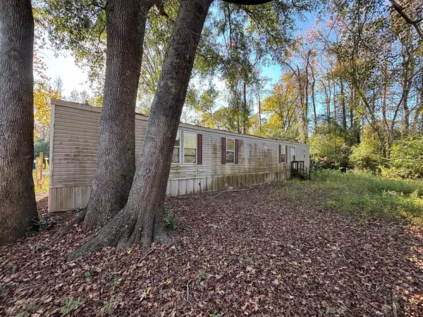 a view of a house with a yard and tree s