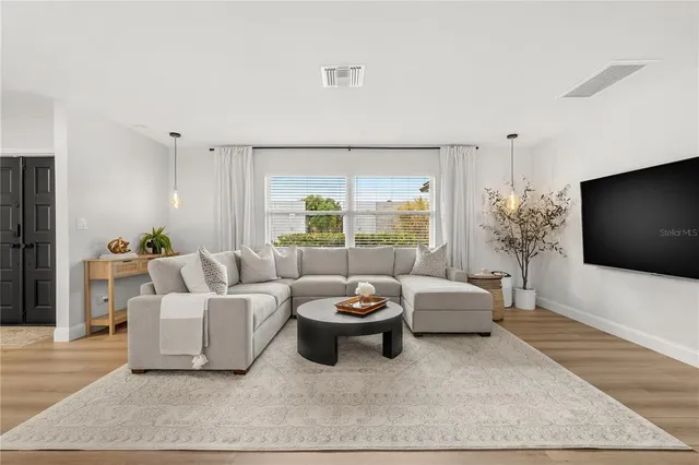 a living room with a couch and a dresser next to a window